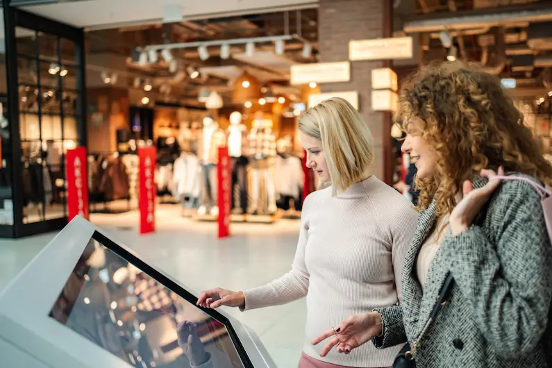 Retail and commerce — shopper using an interactive touchscreen kiosk